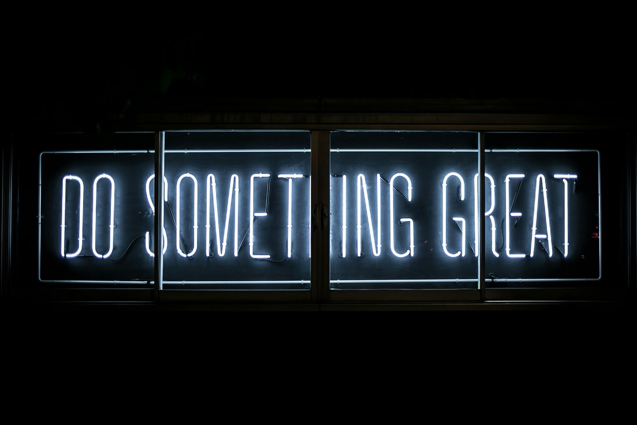 „Do Something Great“-Neon-Schriftzug hinter einem mehrteiligen Fenster